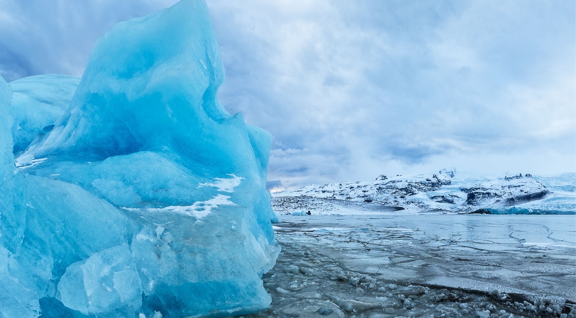 Bright blue iceberg in the frozen Fjallsárlón lagoon in February